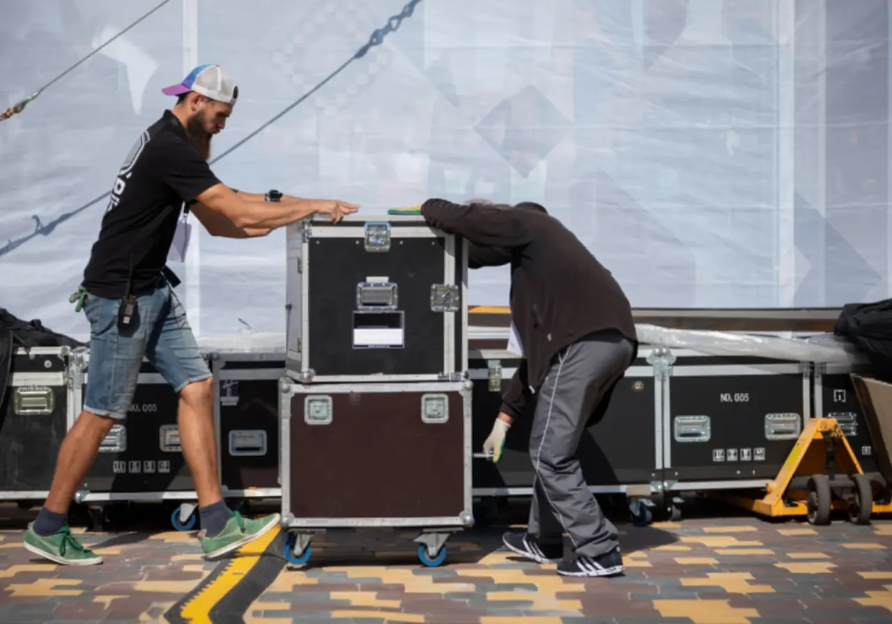 Crew rolling road cases during an event load-in