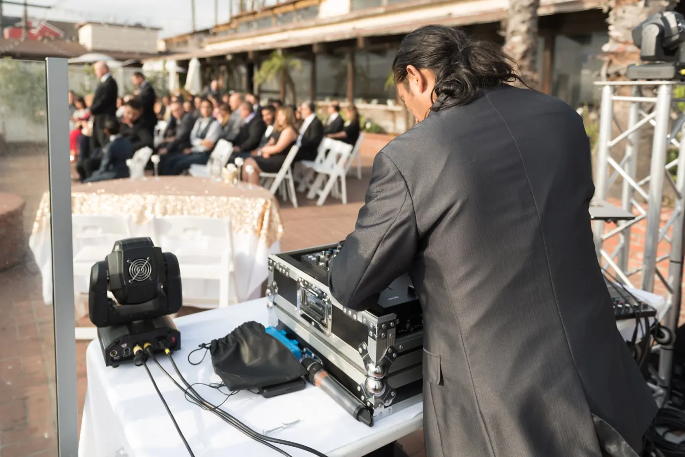 Audio technician setting up for an outdoor wedding ceremony
